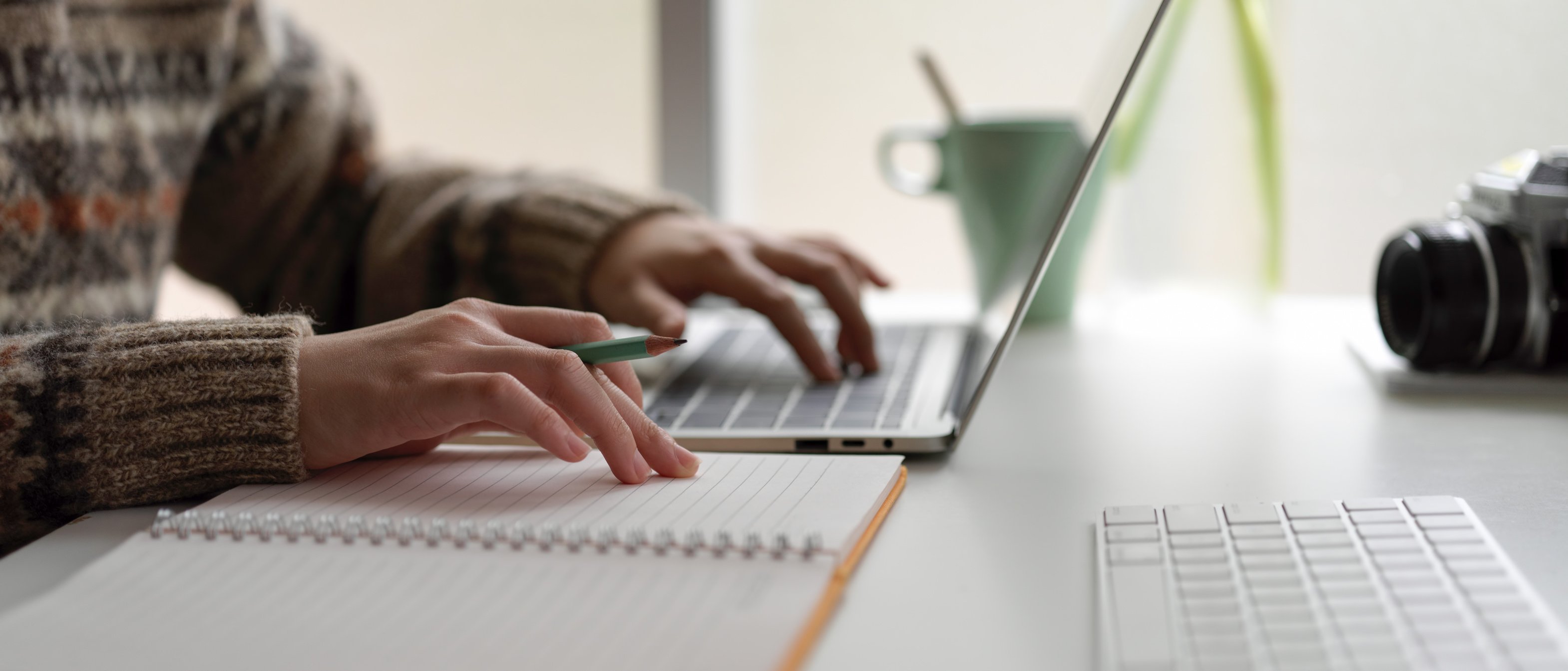 Female university student preparing informations for her presentation with laptop and blank notebook